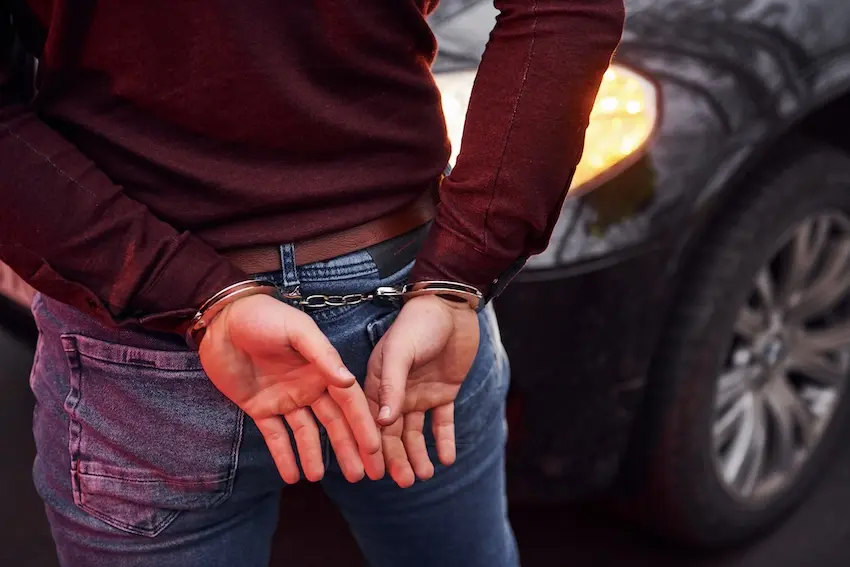 Man being arrested for DUI by a police officer on a South Carolina roadside at night